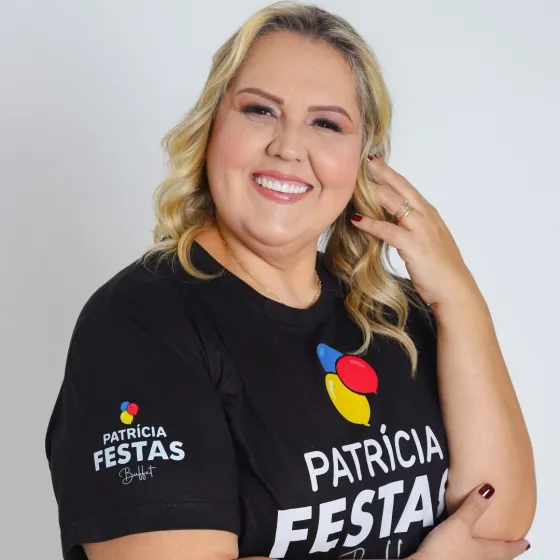 Patrícia Pessoa sorrindo, com a camiseta preta da Patrícia Festas