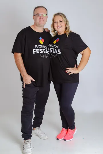Patrícia e Edson abraçados e sorrindo, os dois com a camiseta preta da Patrícia Festas